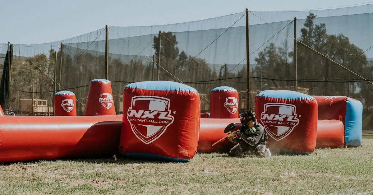 Paintball player in padded pants sliding into cover during competitive outdoor play