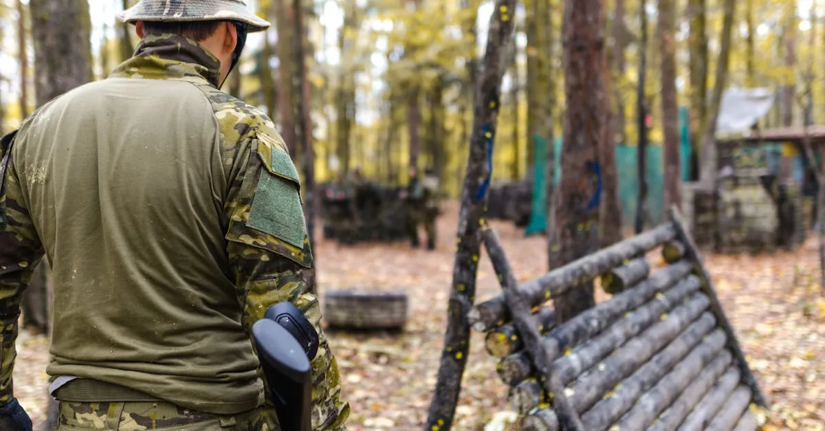 Player in camouflage aiming a woodsball gun through forest cover on a wooded field