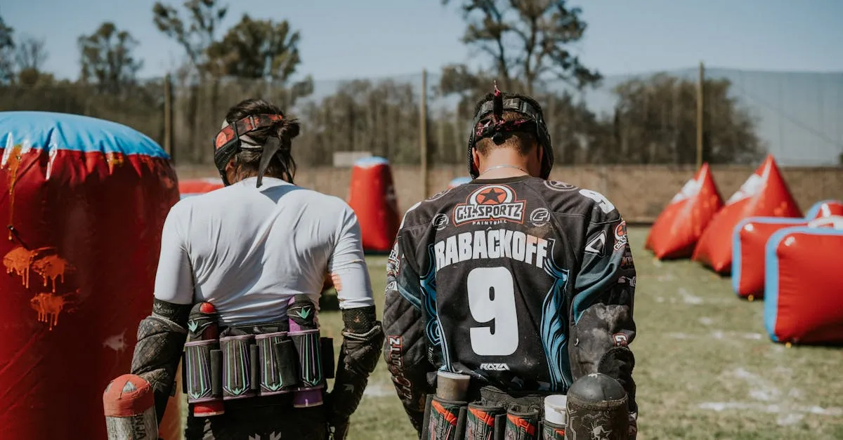 Two players on a field demonstrating different types of paintball guns in action